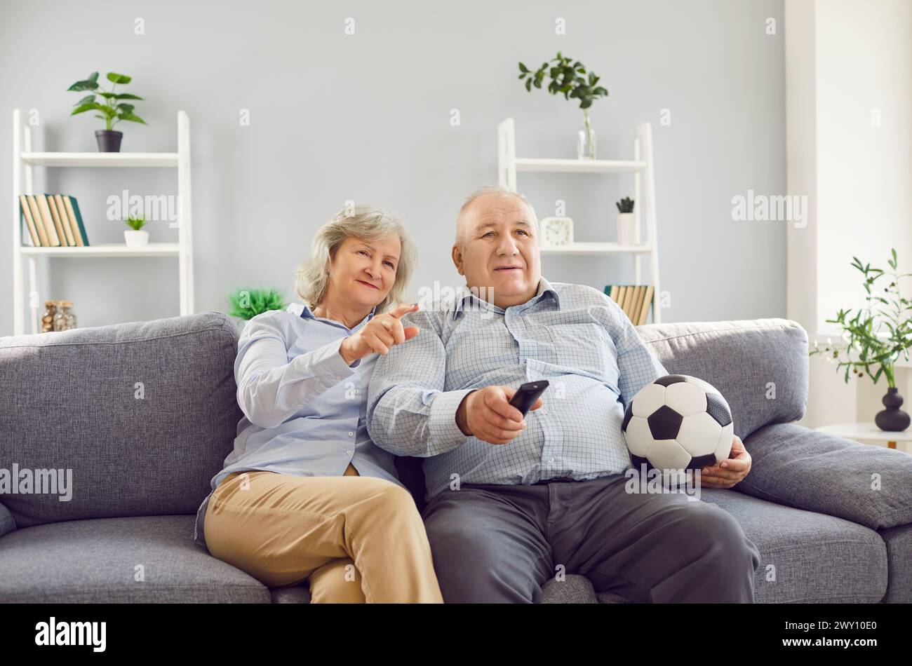 Elderly Family Couple Watching Football Match Together On Tv Stock Photo