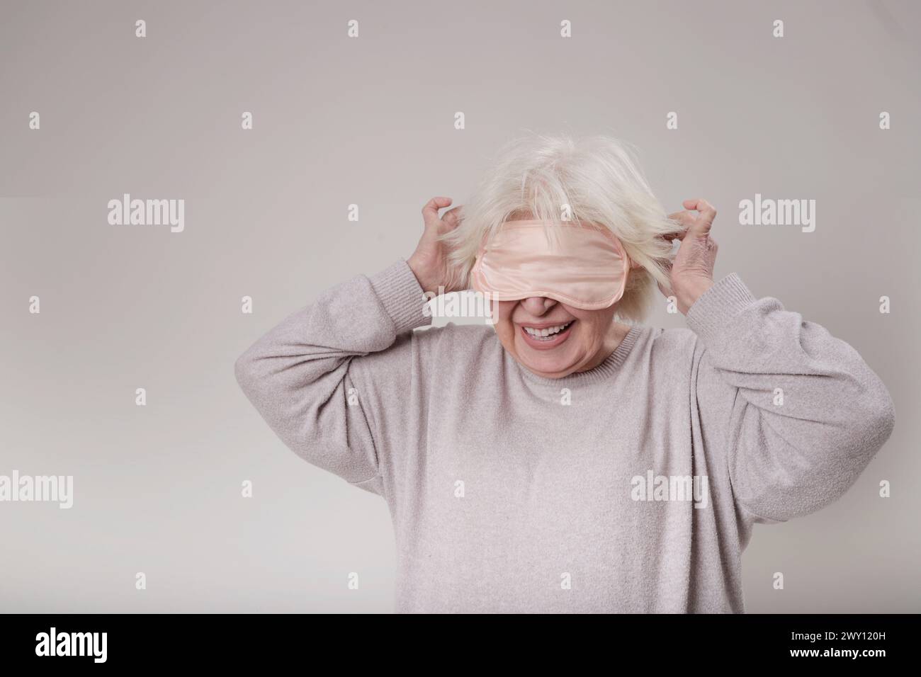Senior woman with sleep mask on studio Stock Photo