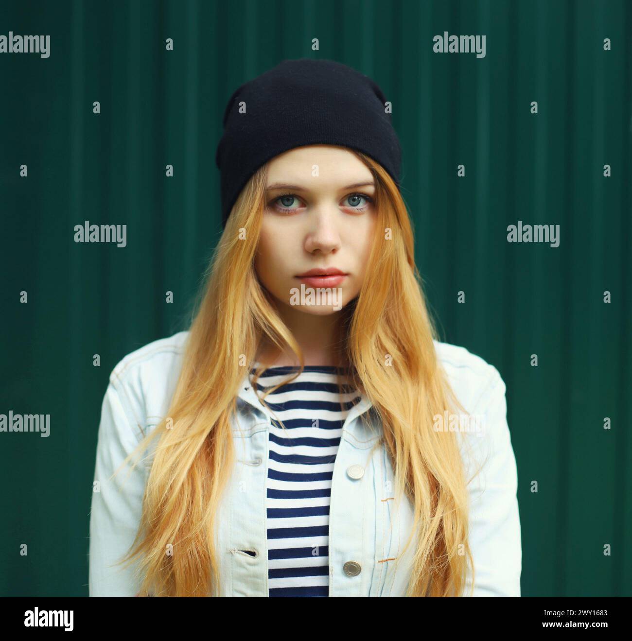 Modern caucasian teenager girl in black hat posing on city street Stock ...