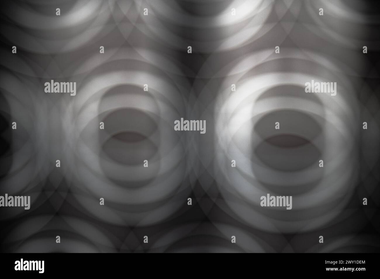 Abstract image in gray tones of multiple blurred circles creating the sensation of depth. Wallpaper, patterns, backgrounds. Stock Photo