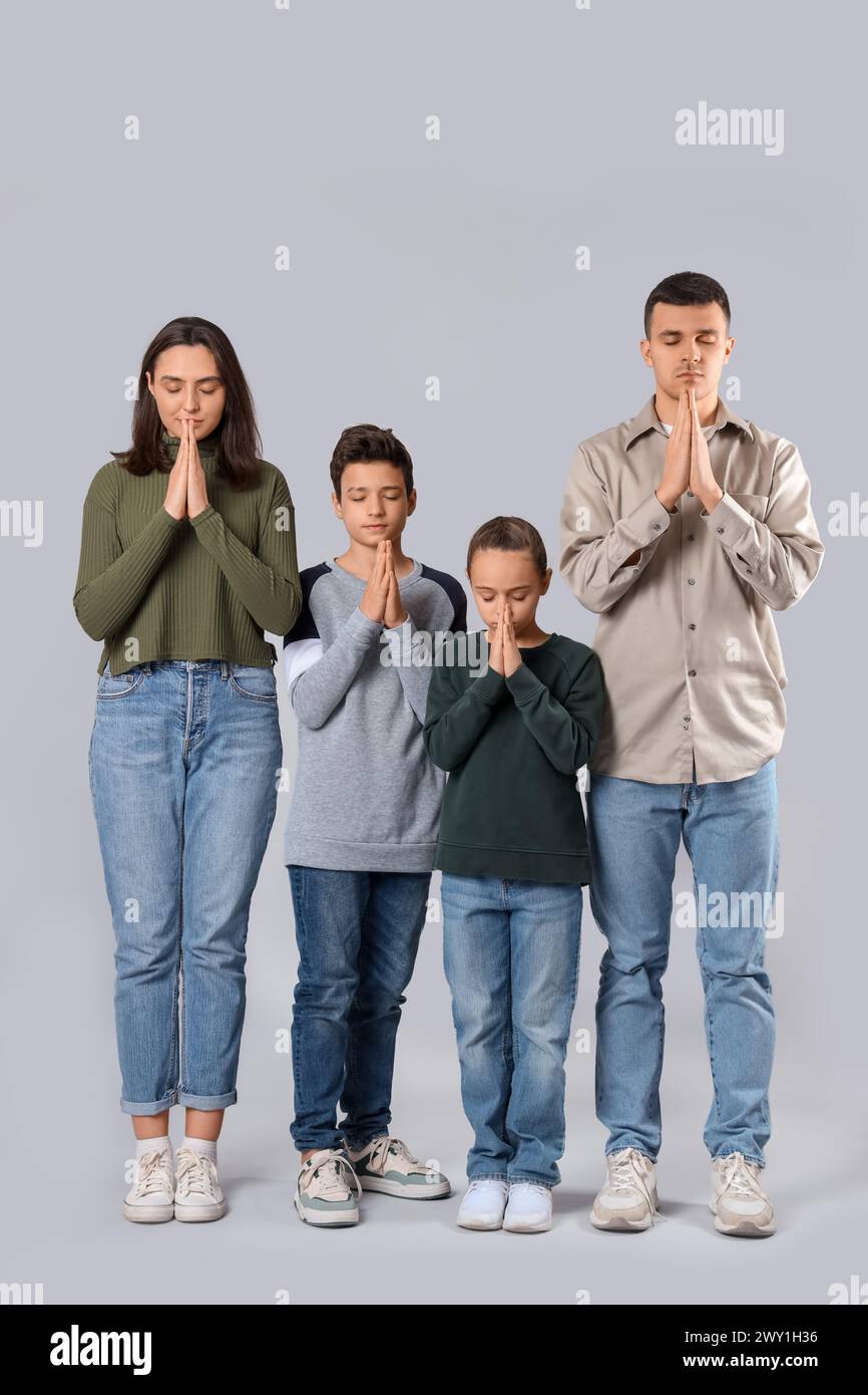 Family praying on light background Stock Photo