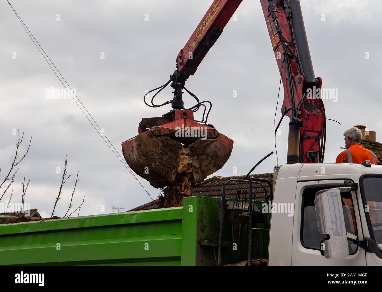 Rubble grab lorry removing stone and soil with a clamshell bucket on a crane. Stock Photo