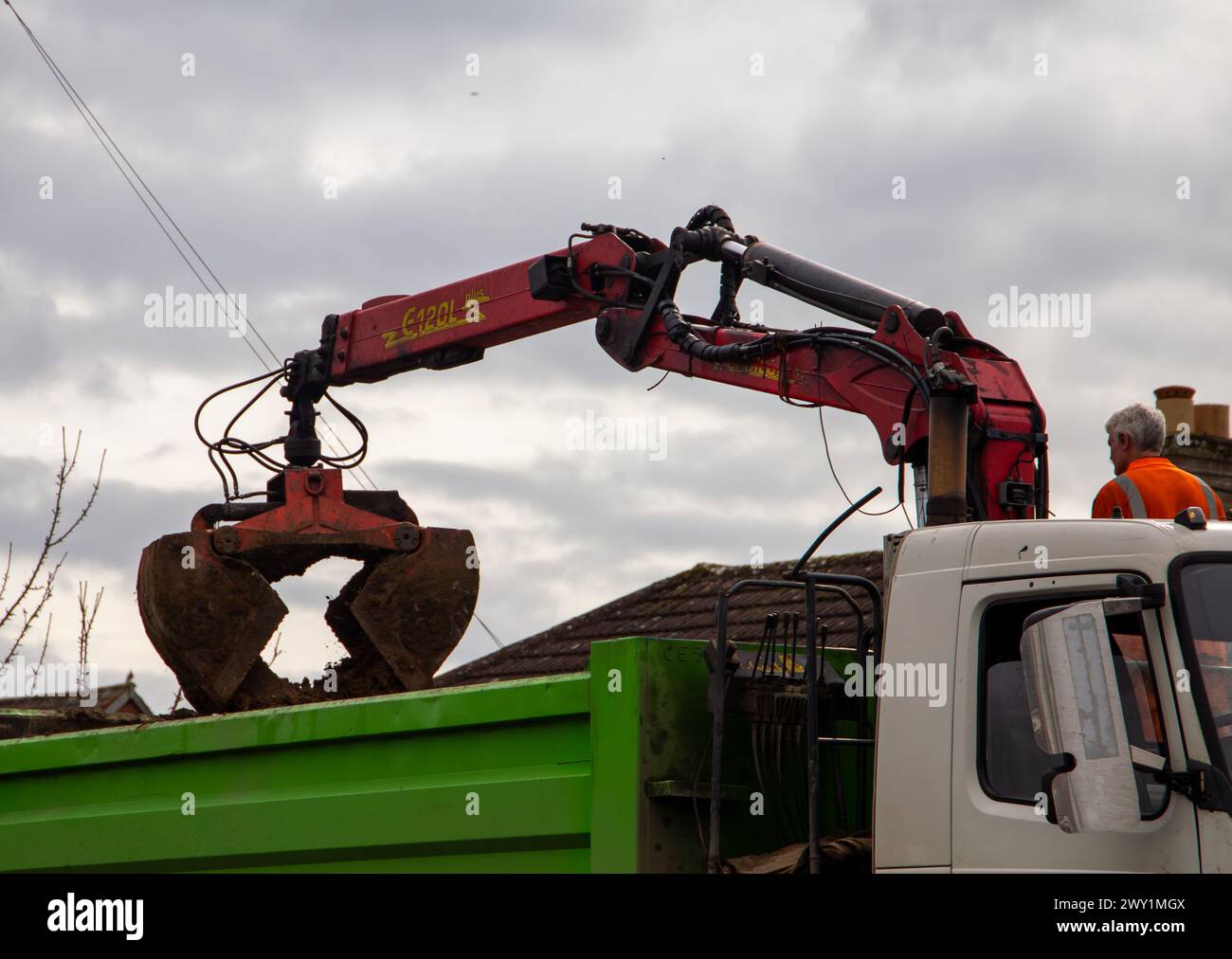 Rubble grab lorry removing stone and soil with a clamshell bucket on a crane. Stock Photo