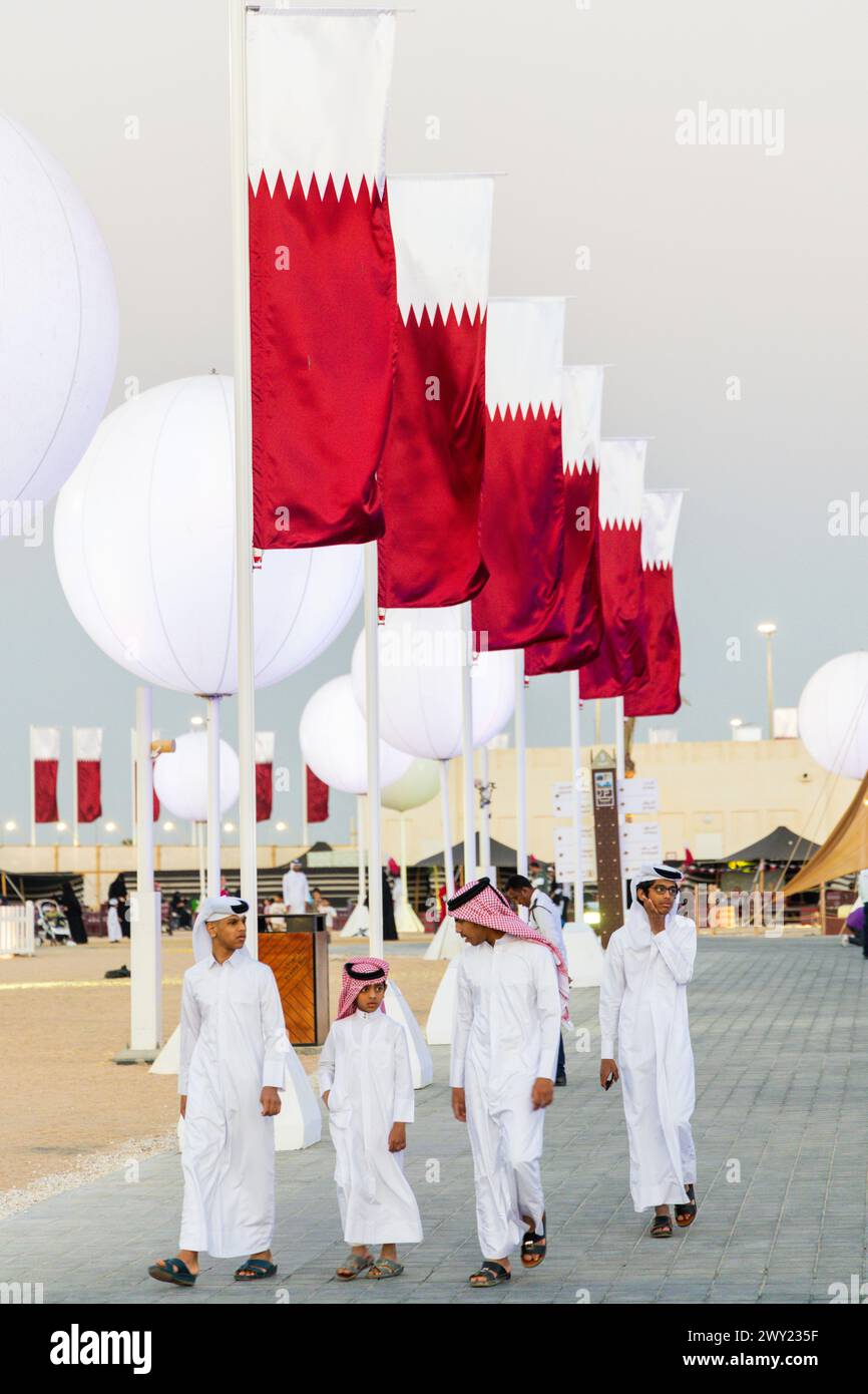 The Qatari youngers walking at the Al Darb Saai in Umm Salal Mohammed in Doha, Qatar. During celebrate Qatar national day. Stock Photo