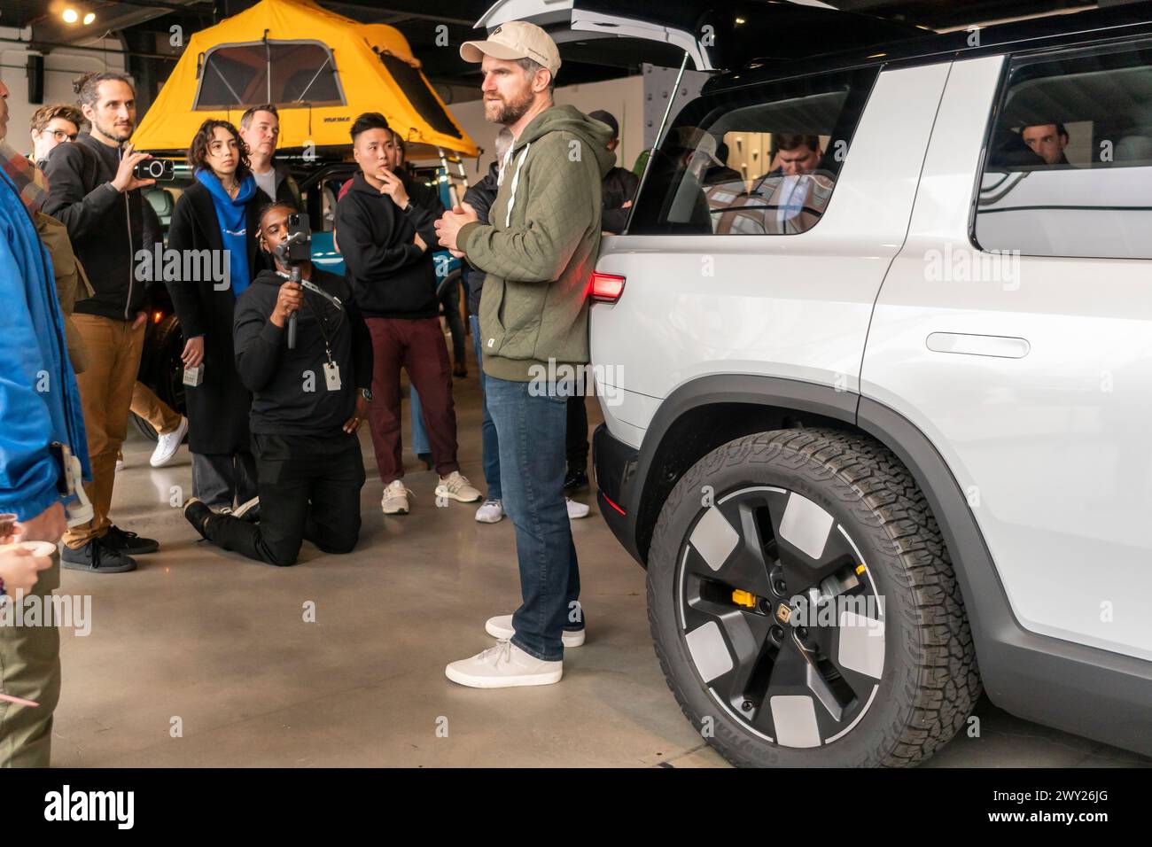 Fans of Rivian electric vehicles in awe of a prototype of the Rivian R2 at Rivian Spaces in the Meatpacking District in New York on Wednesday, March 27, 2024. Rivian announced that it had received over 68,000 reservations for the new $45,000 ev which will not go into production until the first half of 2026. (© Richard B. Levine) Stock Photo