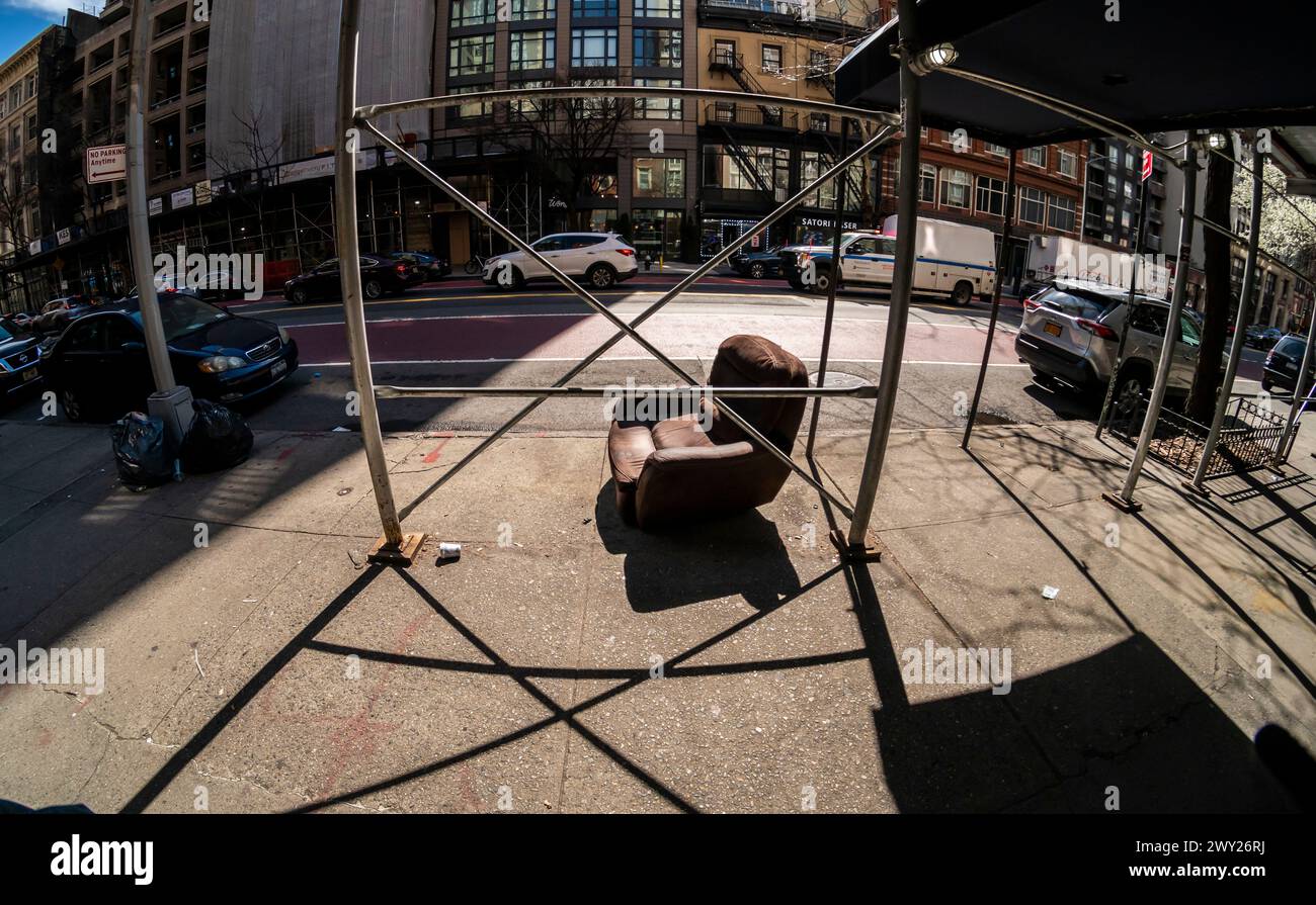 A discarded armchair beneath scaffolding the Chelsea neighborhood in New York on Sunday, March 31, 2024. (© Richard B. Levine) Stock Photo