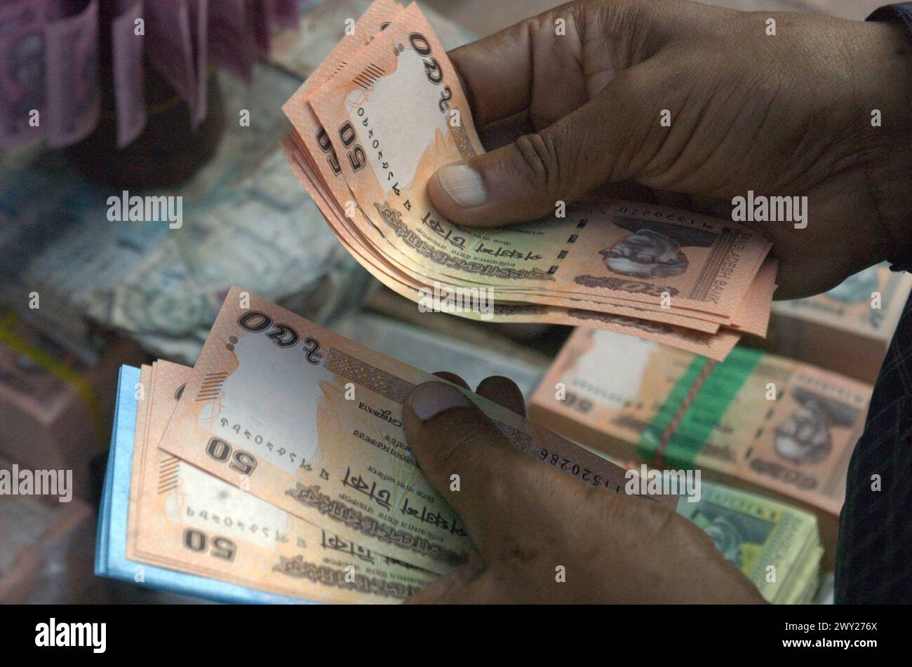 Dhaka, Bangladesh. 4th Apr, 2024. A man counts 50 taka bank notes bought from a roadside shop ahead of the Eid festival in Dhaka. People purchase new money to give gifts to their loved ones during Eid. (Credit Image: © MD Mehedi Hasan/ZUMA Press Wire) EDITORIAL USAGE ONLY! Not for Commercial USAGE! Stock Photo