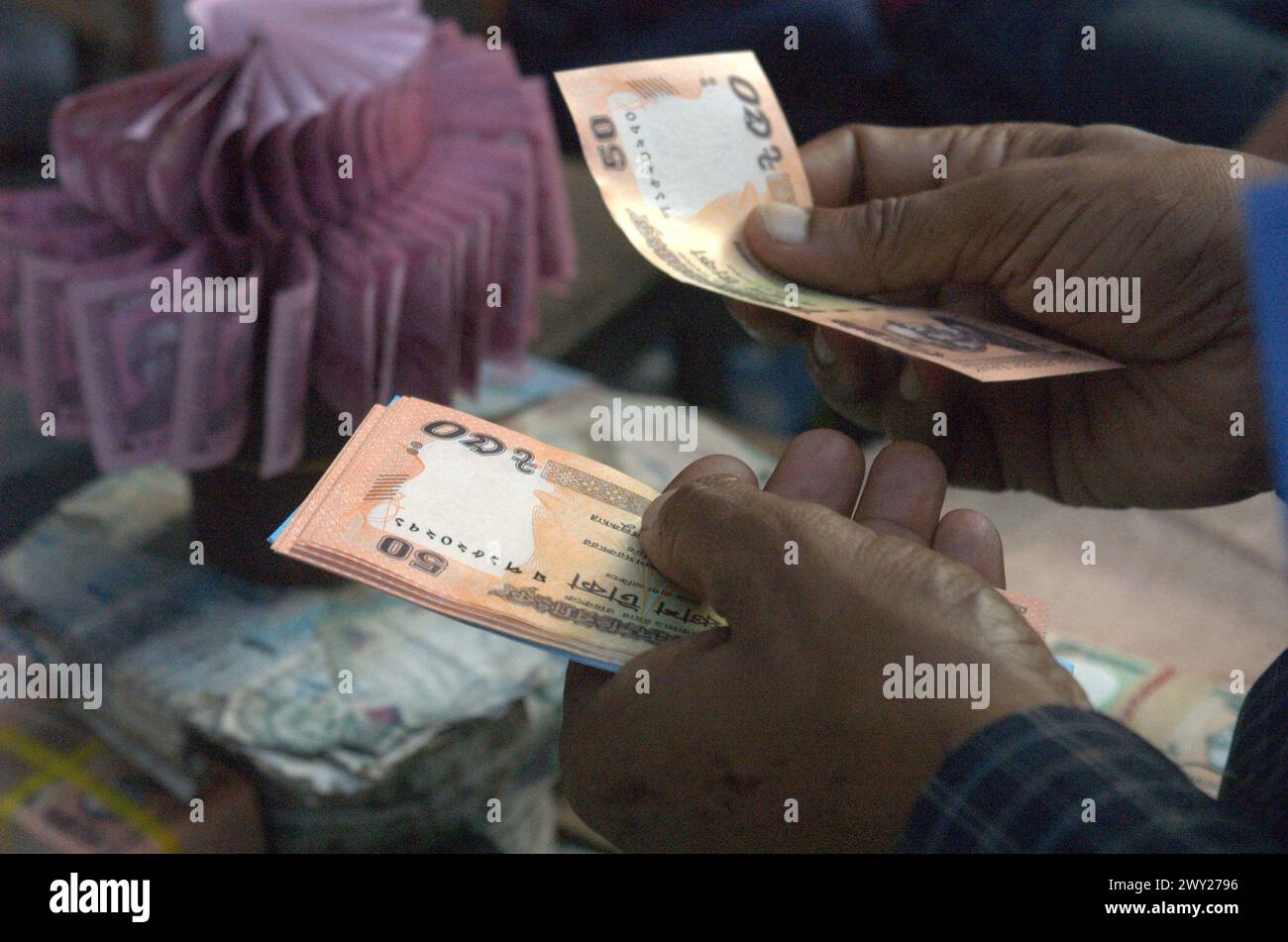 Dhaka, Bangladesh. 4th Apr, 2024. A customer counts 50 taka bank notes bought from a roadside shop ahead of the Eid festival in Dhaka. People purchase new money to give gifts to their loved ones during Eid. (Credit Image: © MD Mehedi Hasan/ZUMA Press Wire) EDITORIAL USAGE ONLY! Not for Commercial USAGE! Stock Photo