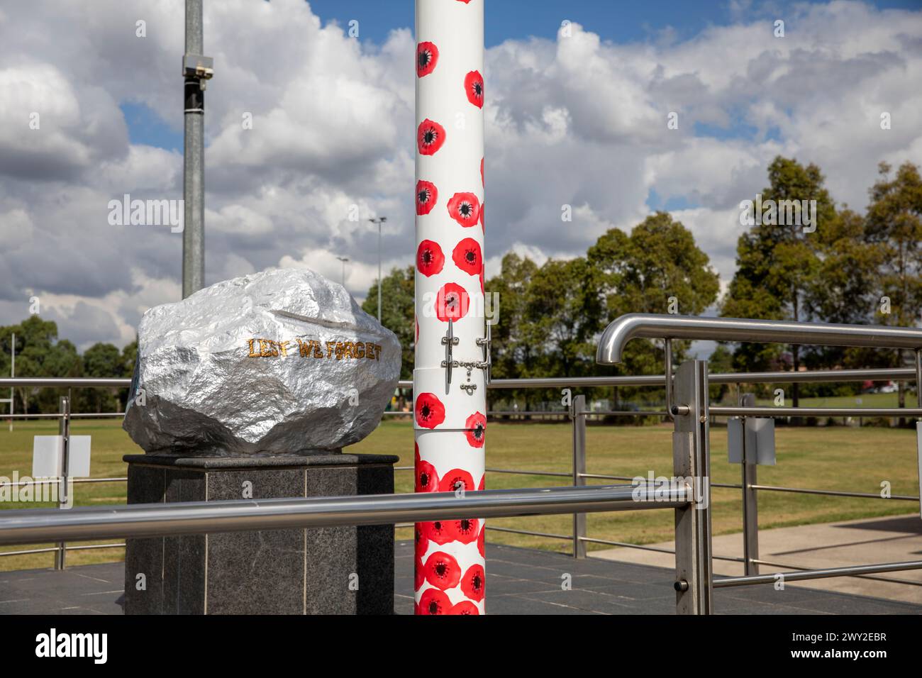 Australian war memorial, in the Centenary of Anzac Reserve on the Kellyville Castle Hill suburb boundary with poppies on the flagpole and stone,NSW Stock Photo