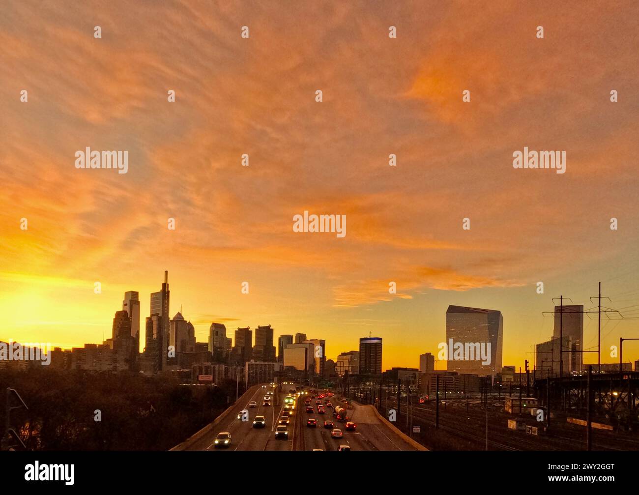 Traffic moves along the Schuylkill Expressway as the sun rises behind Center City Philadelphia. Stock Photo