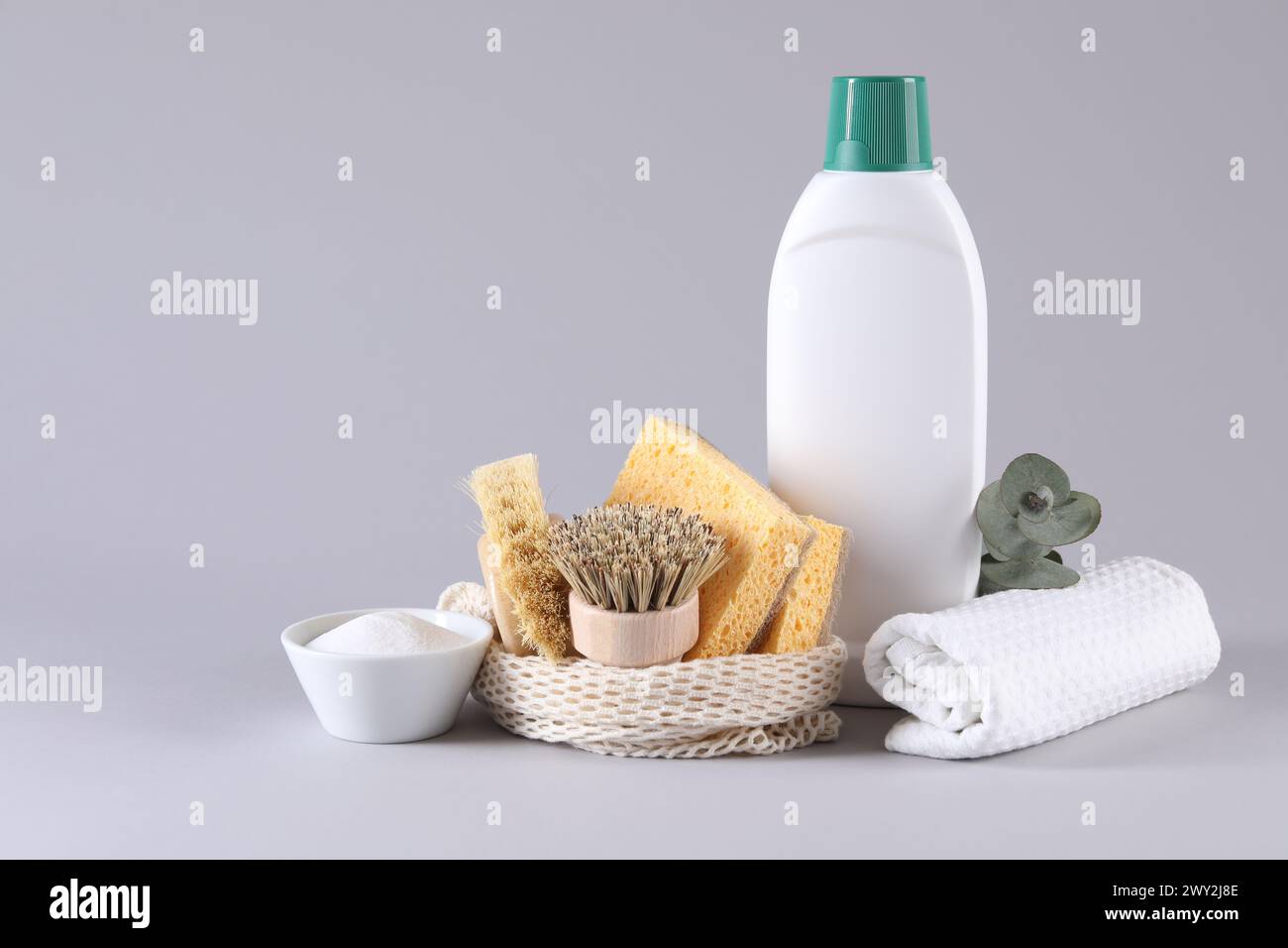 Bottles of cleaning product, sponges, brushes, rag and baking soda on ...