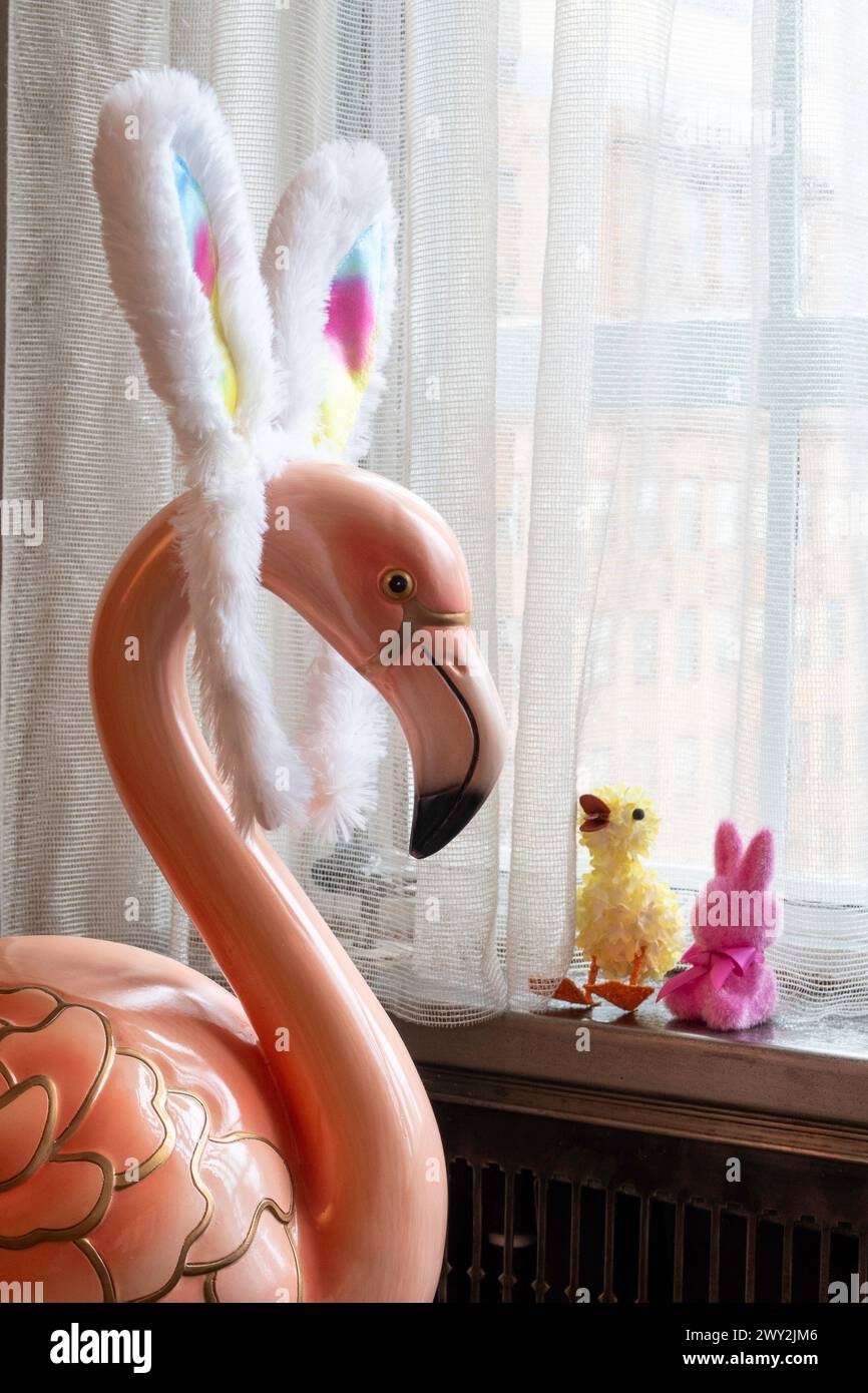 Humorous juxtaposition of a large pink flamingo statue, wearing rainbow