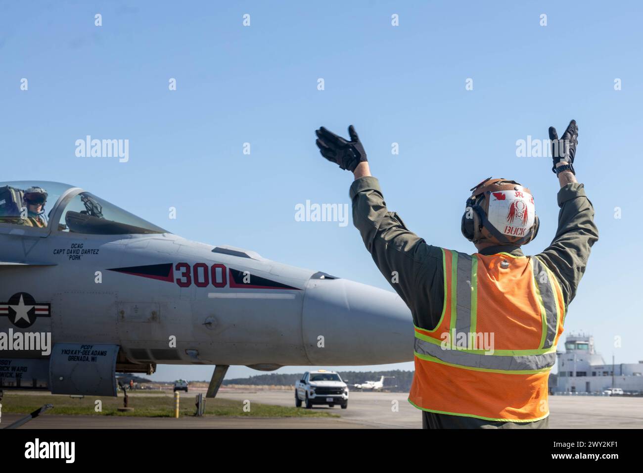 U.S. Marine Corps Cpl. Brandon Buck, a bulk fuel specialist assigned to Headquarters and Headquarters Squadron, Marine Corps Air Station Cherry Point, signals to the pilot of an F/A-18E Super Hornet, assigned to Strike Fighter Squadron 31, Naval Air Force Atlantic, on the flight line at MCAS Cherry Point, North Carolina, March 21, 2024. MCAS Cherry Point Station Fuels is responsible for receiving, testing, storing, and dispensing various petroleum products in support of ground and aviation operations on the installation. (U.S. Marine Corps photo by Lance Cpl. Lauralle Gavilanes) Stock Photo