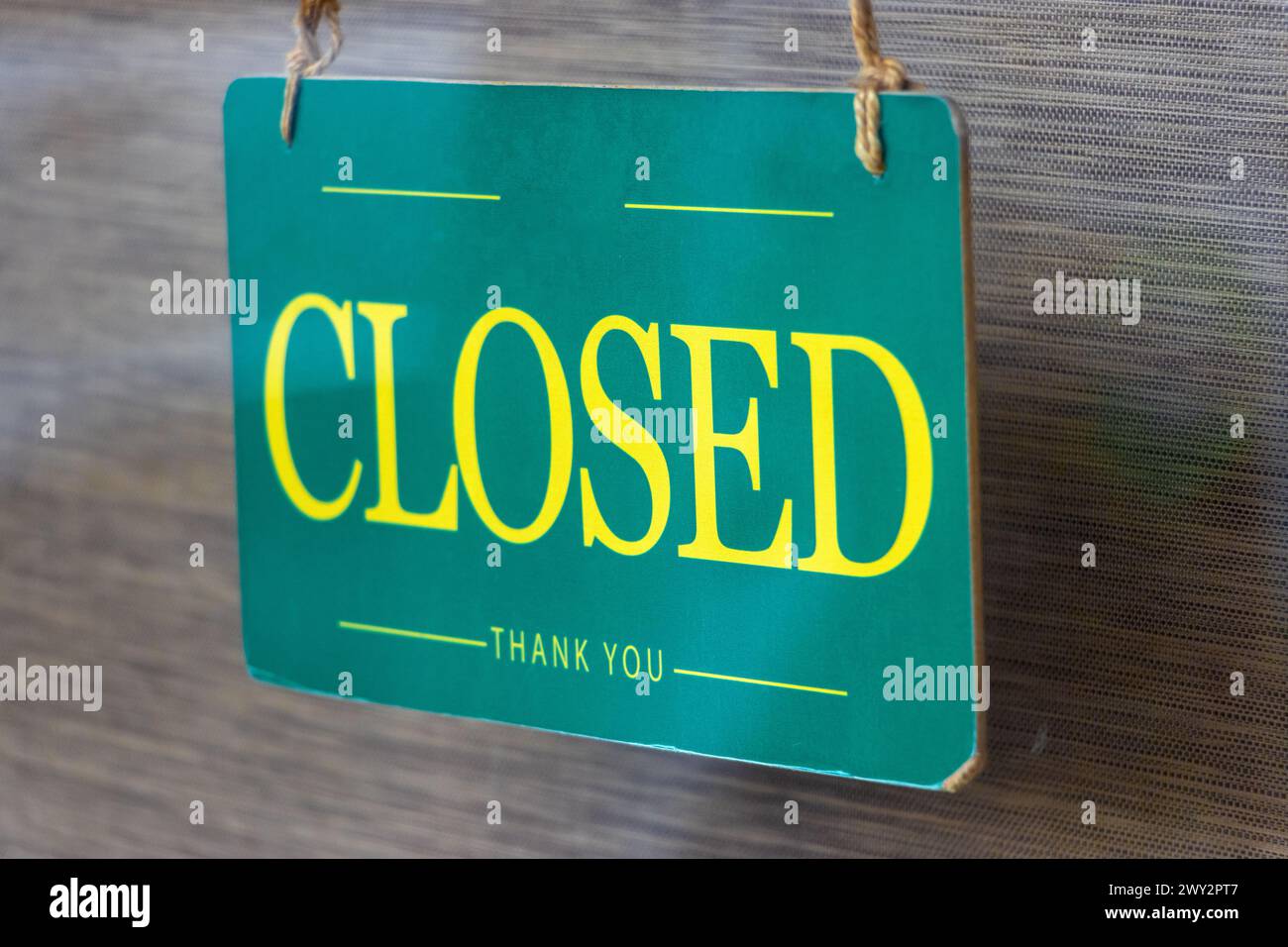 Behind the glass door hangs a sign that says Closed Stock Photo