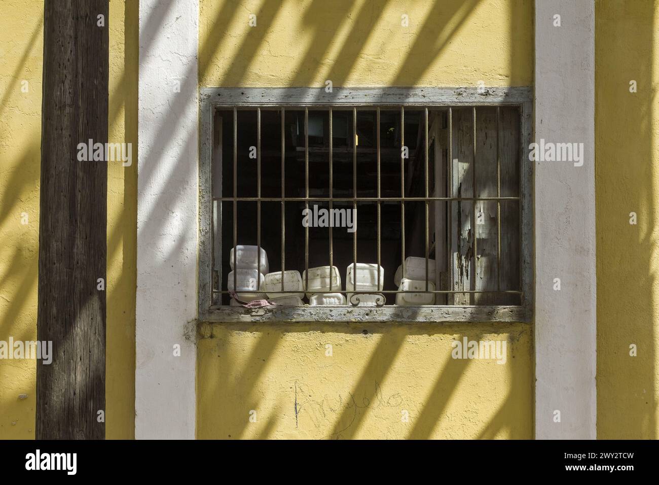 Diverse objects on a window protected by a metal grate, Havana, Cuba Stock Photo
