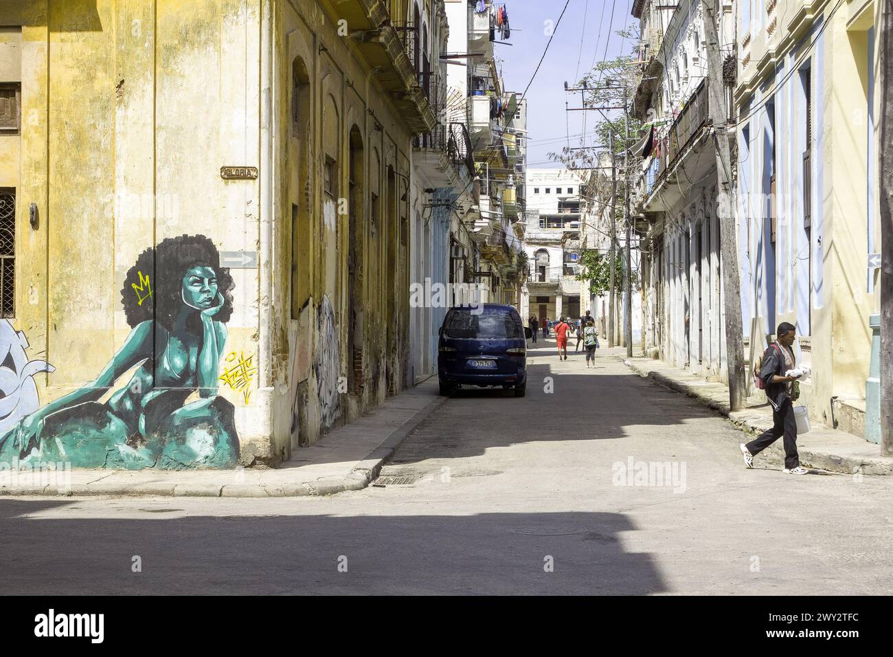 Cuban person walking in street, urban graffiti art, weathered building facade, avana, Cuba Stock Photo