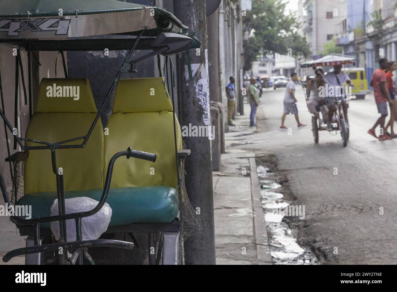 A bicitaxi and people on a city street, Havana, Cuba Stock Photo