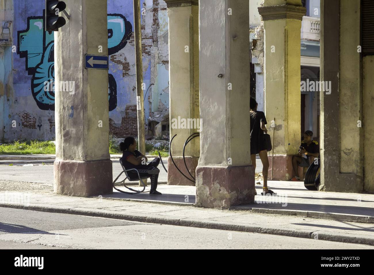 Cuban people on a porch of a weathered building, Havana, Cuba Stock Photo