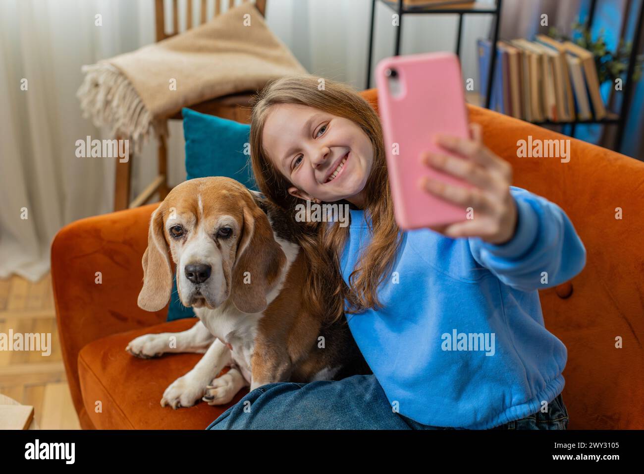 POV of smiling young girl child with cute beagle dog and taking selfie ...