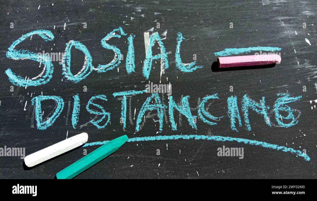 "Social Distancing" text on a black and crayon background Stock Photo