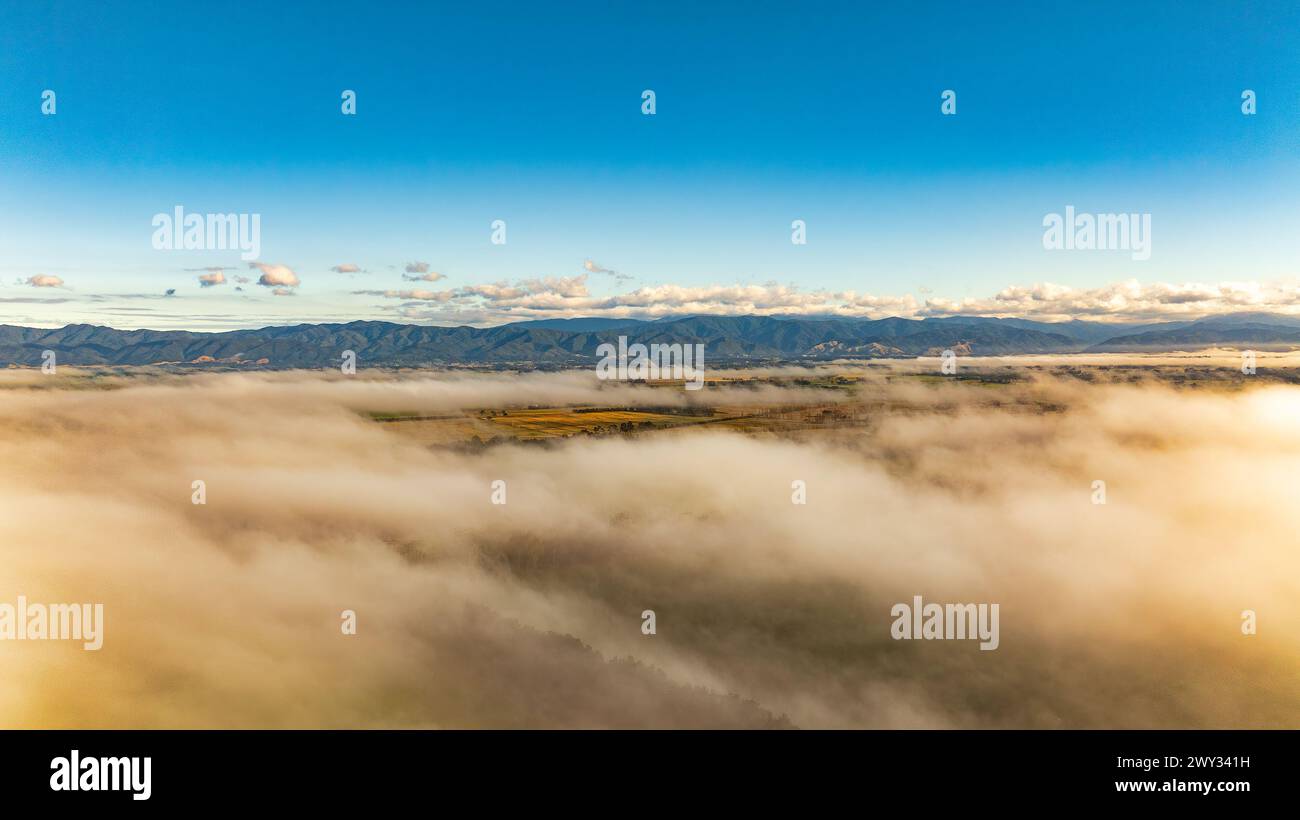 Low cloud in the rural valley with the hill range above the cloud Stock ...