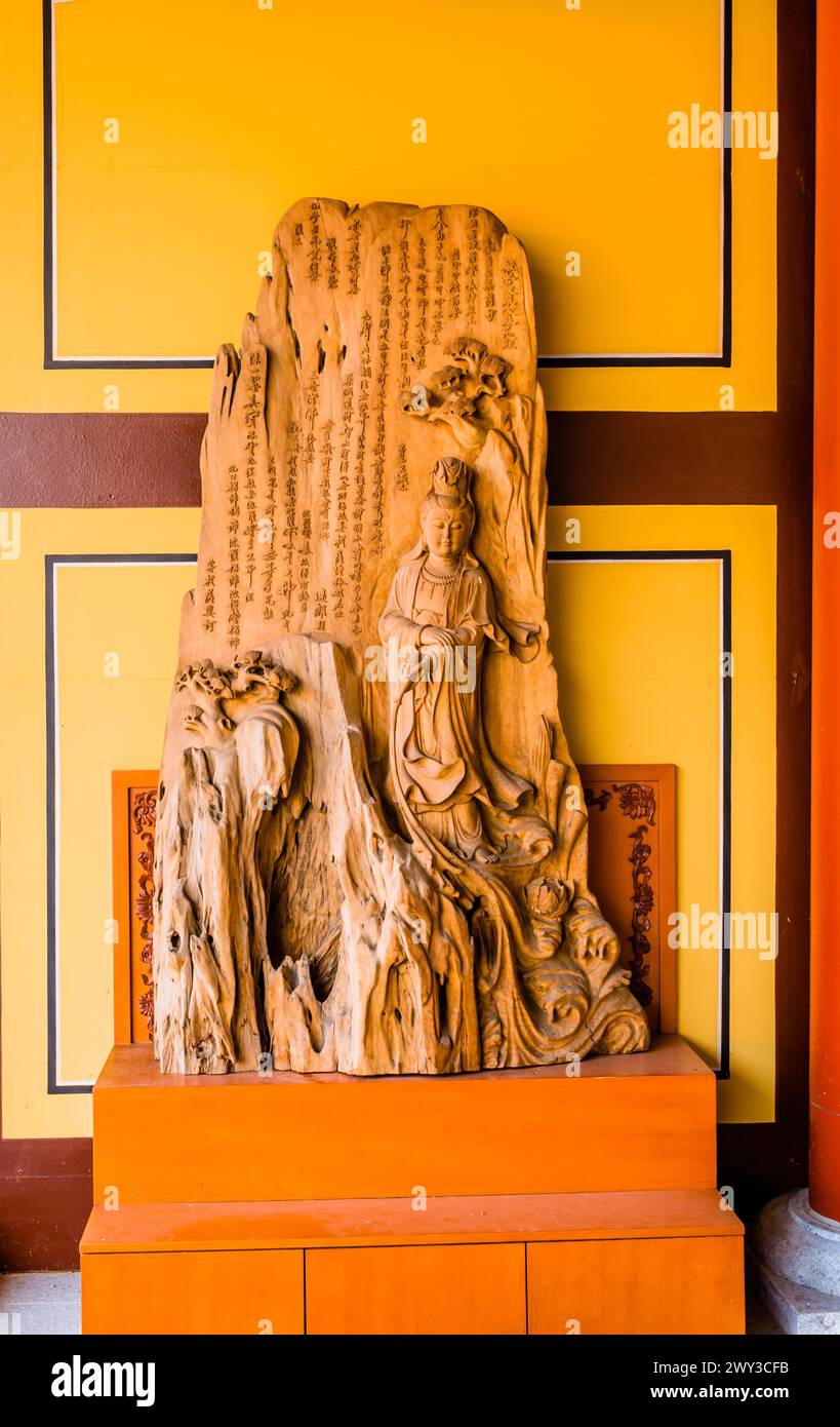 Wood carving of standing Buddha in mountain with Chinese text at Manblsa Temple in Yeongcheon, South Korea Stock Photo