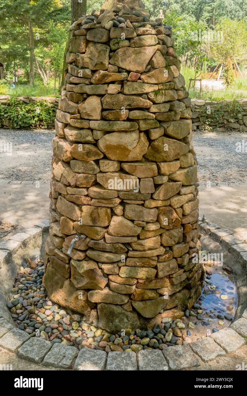 Water fountain built into cairn of stacked stones at recreational forest park in South Korea