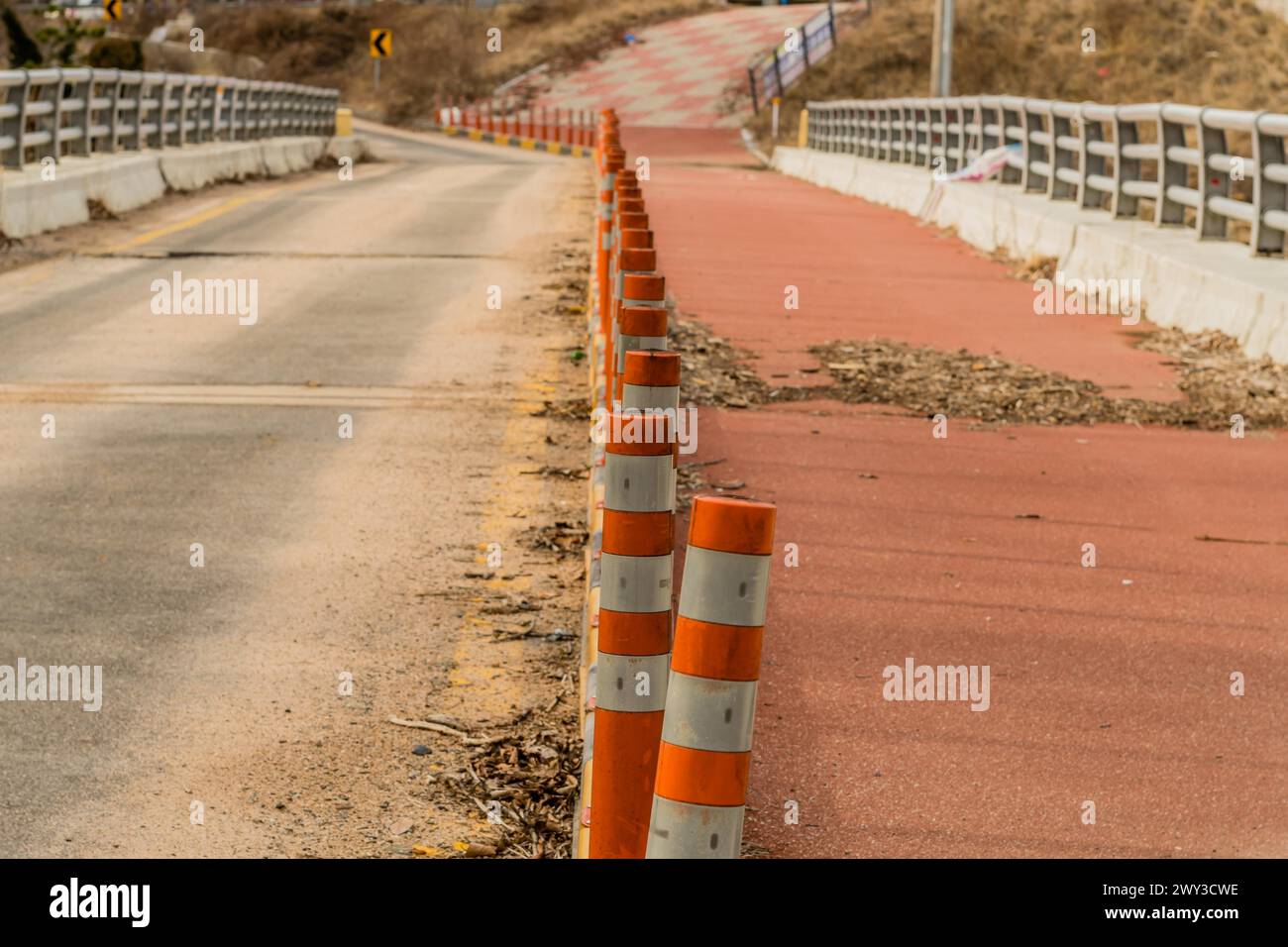 Row of traffic bollards in center of old disused bridge with focus on first bollard and blurred background Stock Photo