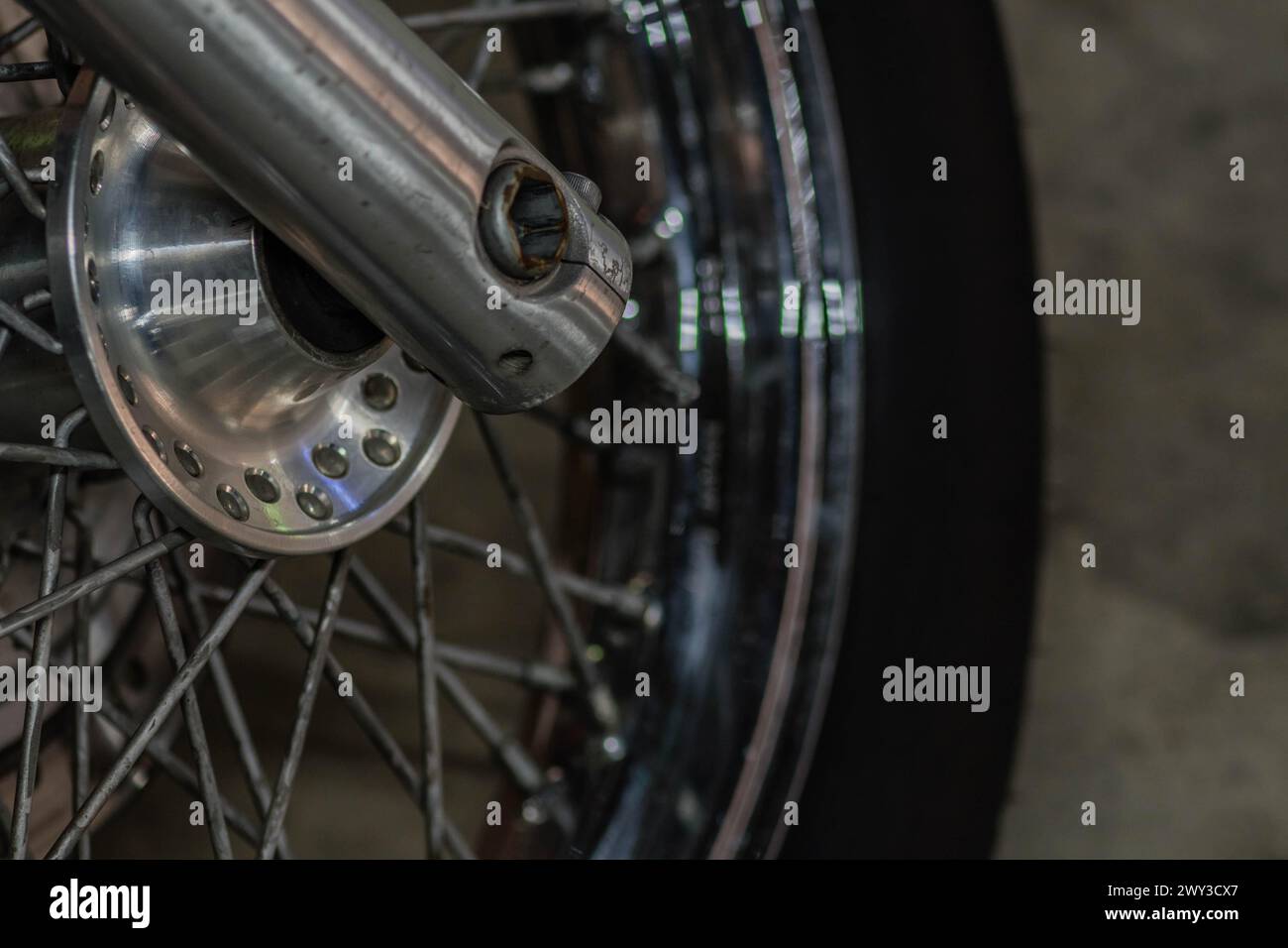 Closeup of motorcycle front wheel and spokes with focus on center wheel