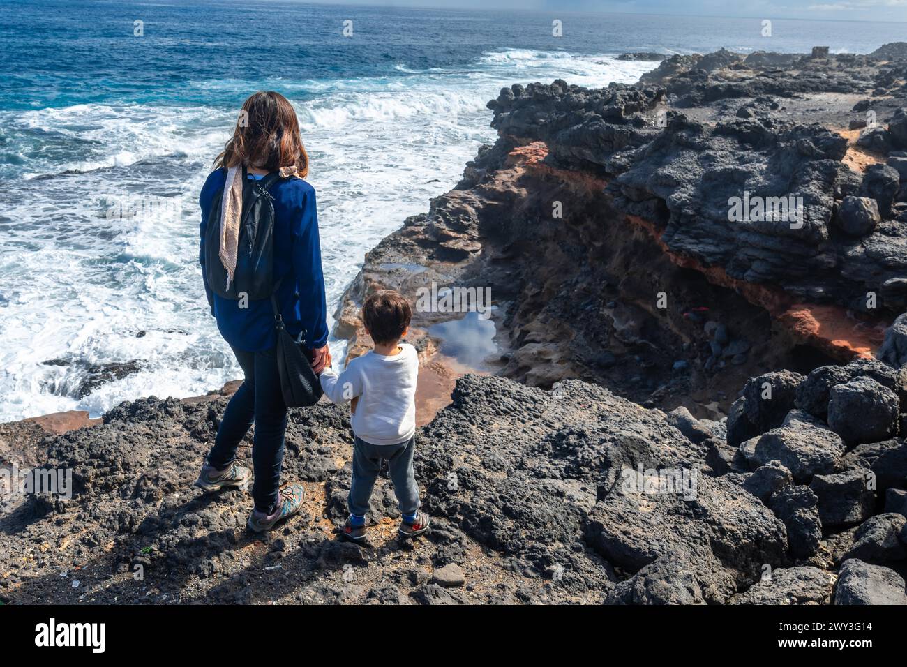 A mother with her son looking at the Bufadero de La Garita (Telde), Gran Canaria, Canary Islands Stock Photo