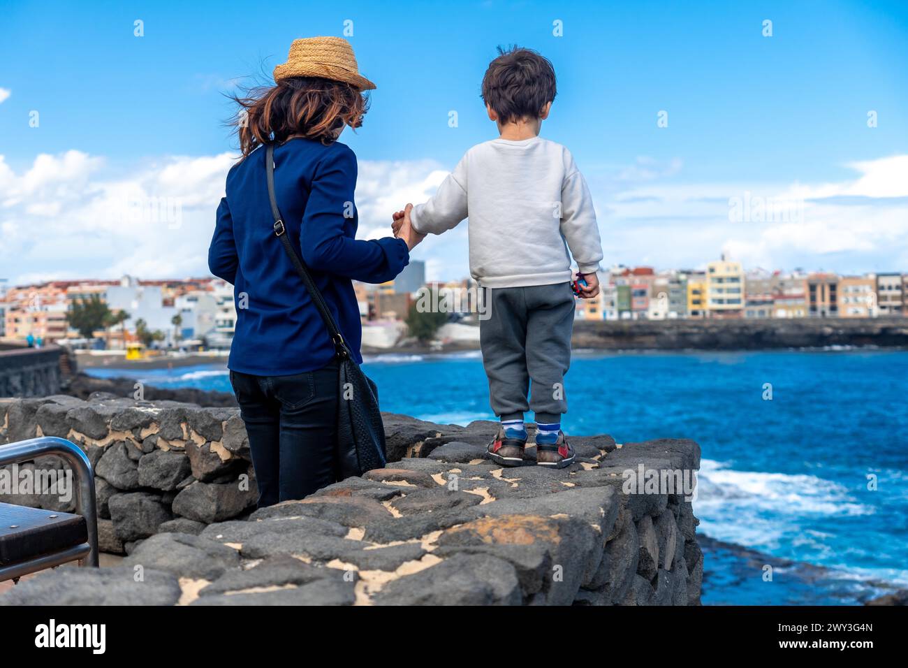 Mother with her son looking at the sea on summer vacation, enjoying family Stock Photo