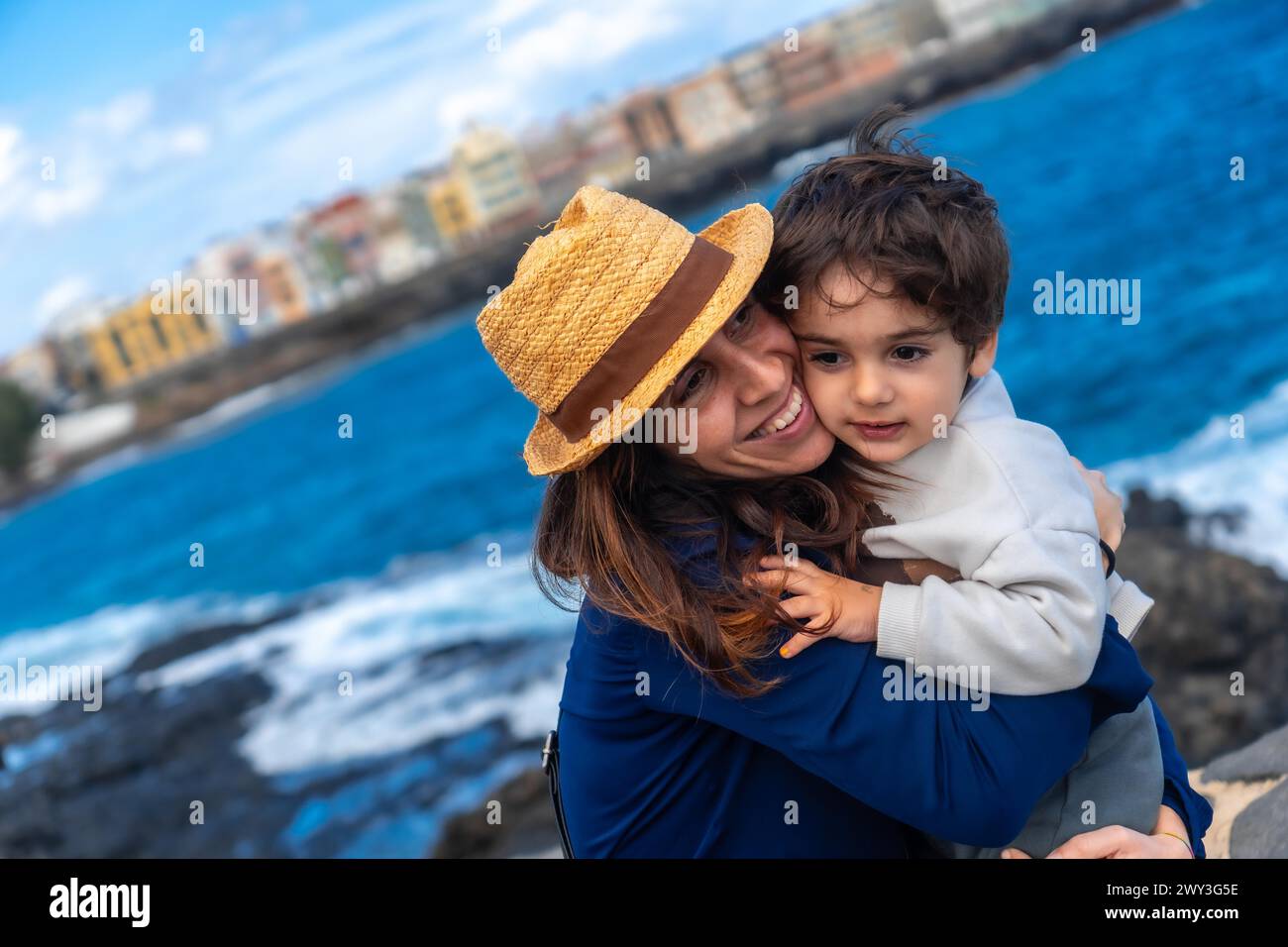 Mother with her son hugging on summer vacation at sea, enjoying family Stock Photo