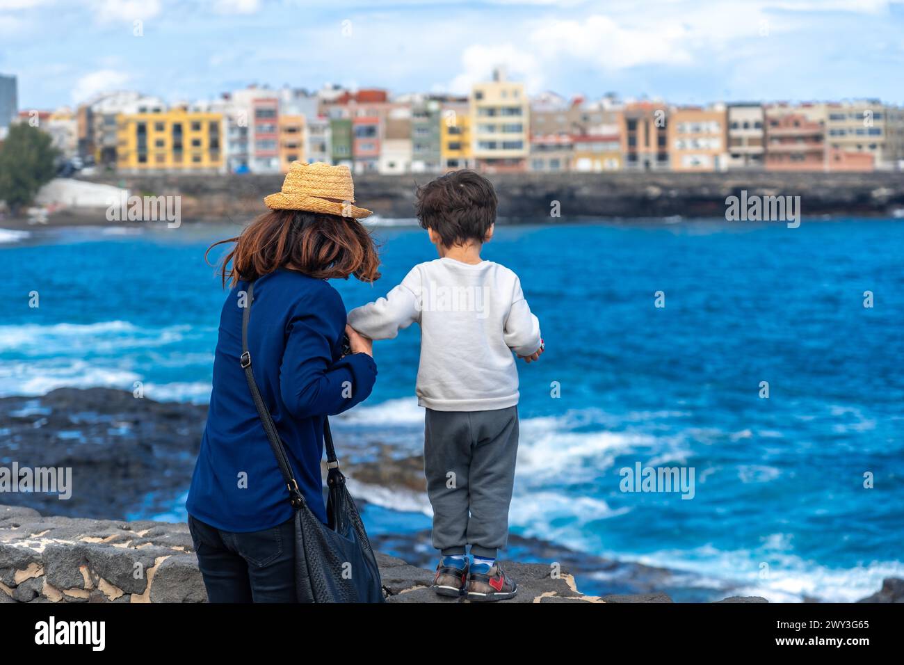 Mother with her son looking at the sea on summer vacation, happy family enjoying Stock Photo