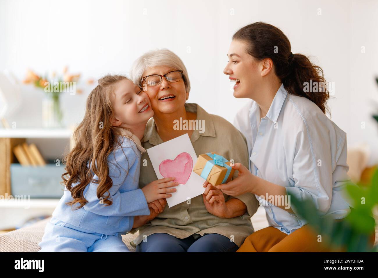 Happy mother's day. Child, mom and granny with gaft box and postcard. Grandma, mum and girl smiling. Family holiday and togetherness. Stock Photo