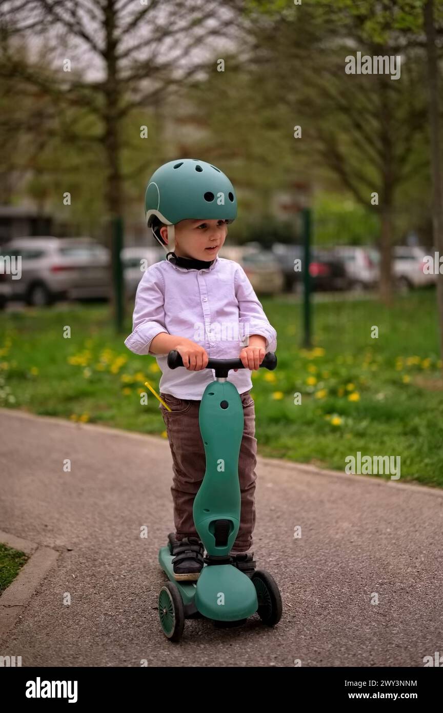 Little toddler on the scooter in the park Stock Photo