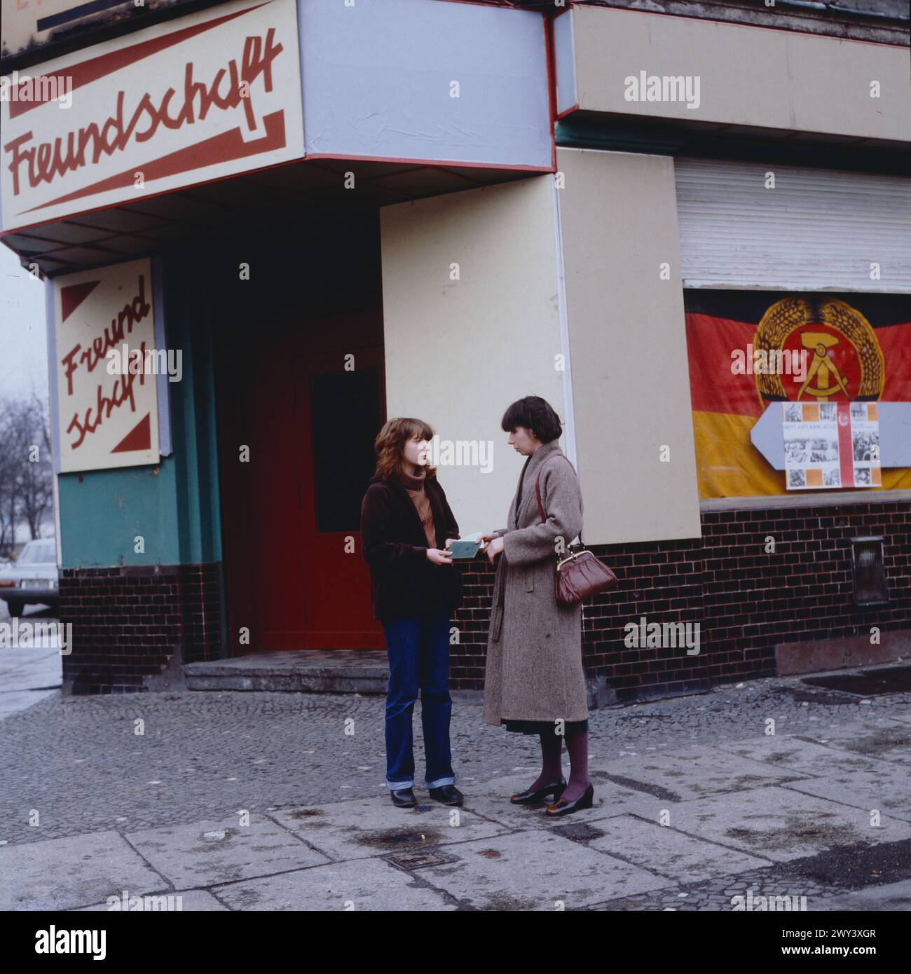 Fluchthelfer gesucht, deutscher Fernsehfilm von 1979, Gerd Oelschlegel, Szene vor einer Kneipe in Ost-Berlin: Sabine Buschmann als Ina und Monika Hansen als Ost-Berlinerin Ella, die von Ina einen Reisepass mit Visum erhält, während Ella legal ausreist, sitzt Ina versteckt unter dem Rücksitz des Autos. Stock Photo