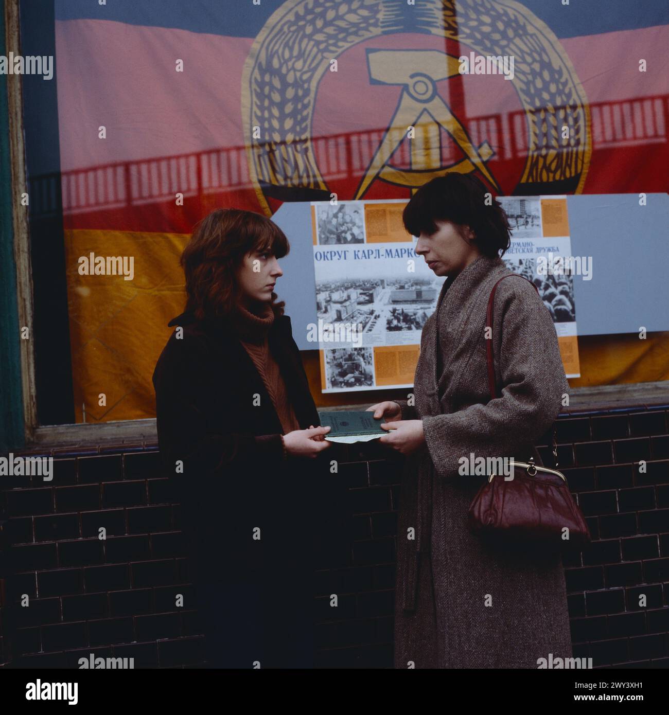 Fluchthelfer gesucht, deutscher Fernsehfilm von 1979, Gerd Oelschlegel, Szene vor einer Kneipe in Ost-Berlin: Sabine Buschmann als Ina und Monika Hansen als Ost-Berlinerin Ella, die von Ina einen Reisepass mit Visum erhält, während Ella legal ausreist, sitzt Ina versteckt unter dem Rücksitz des Autos. Stock Photo