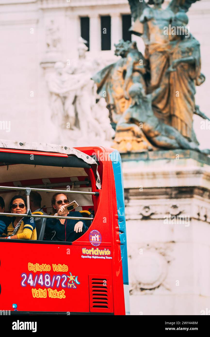 Rome, Italy. Tourists In Red Hop On Hop Off Touristic Bus For Sightseeing In Street Near Altar Of The Fatherland On Piazza Venezia. Famous World Stock Photo