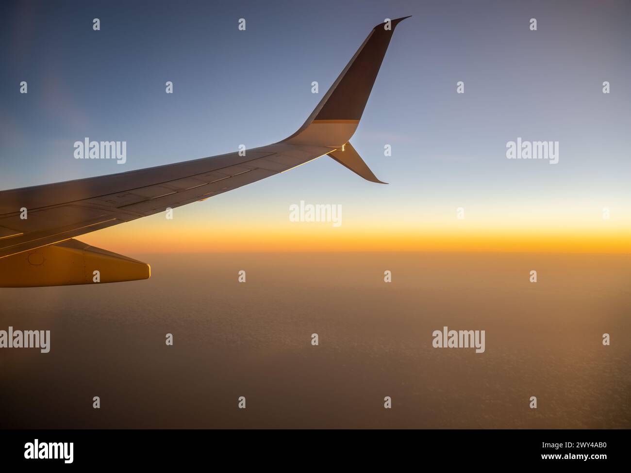 Alaska, USA - Aug 14 2024: United Airlines airplane flying from Anchorage to San Francisco at sunset. Stock Photo