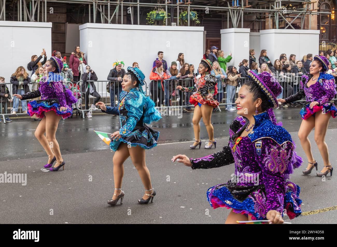 Bolivian dancers in brightly coloured costumes taking part in the procession at the St Patrick's Day parade in London. Stock Photo