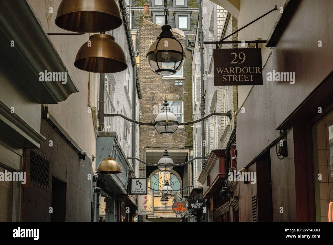Historic buildings flank the narrow alleyway of Rupert Court, Soho. The Ancient lights sign under a window refers to an old UK law. Stock Photo