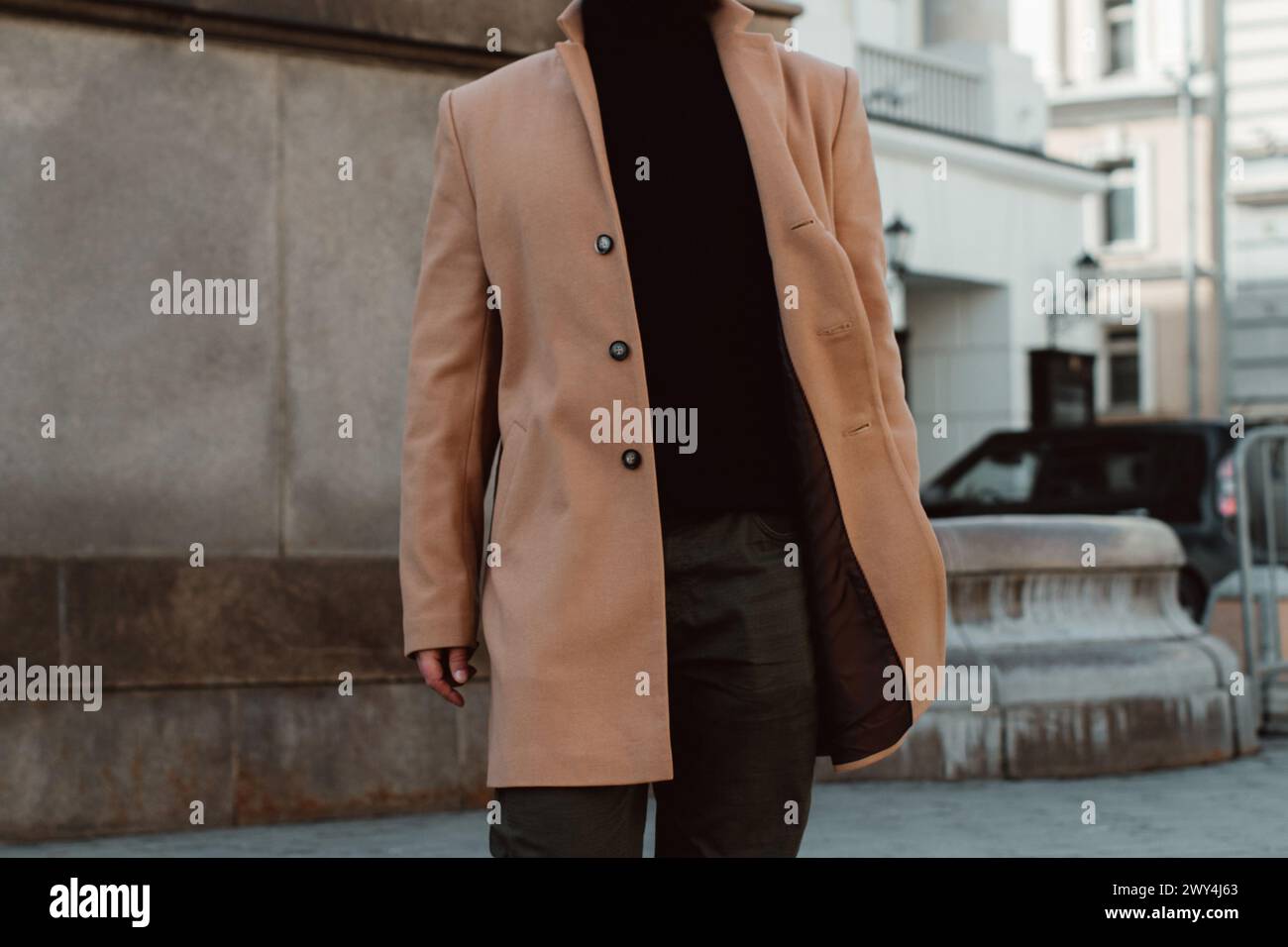 Details of beige brown men's coat, pants and black turtleneck. Classic street outerwear Stock Photo