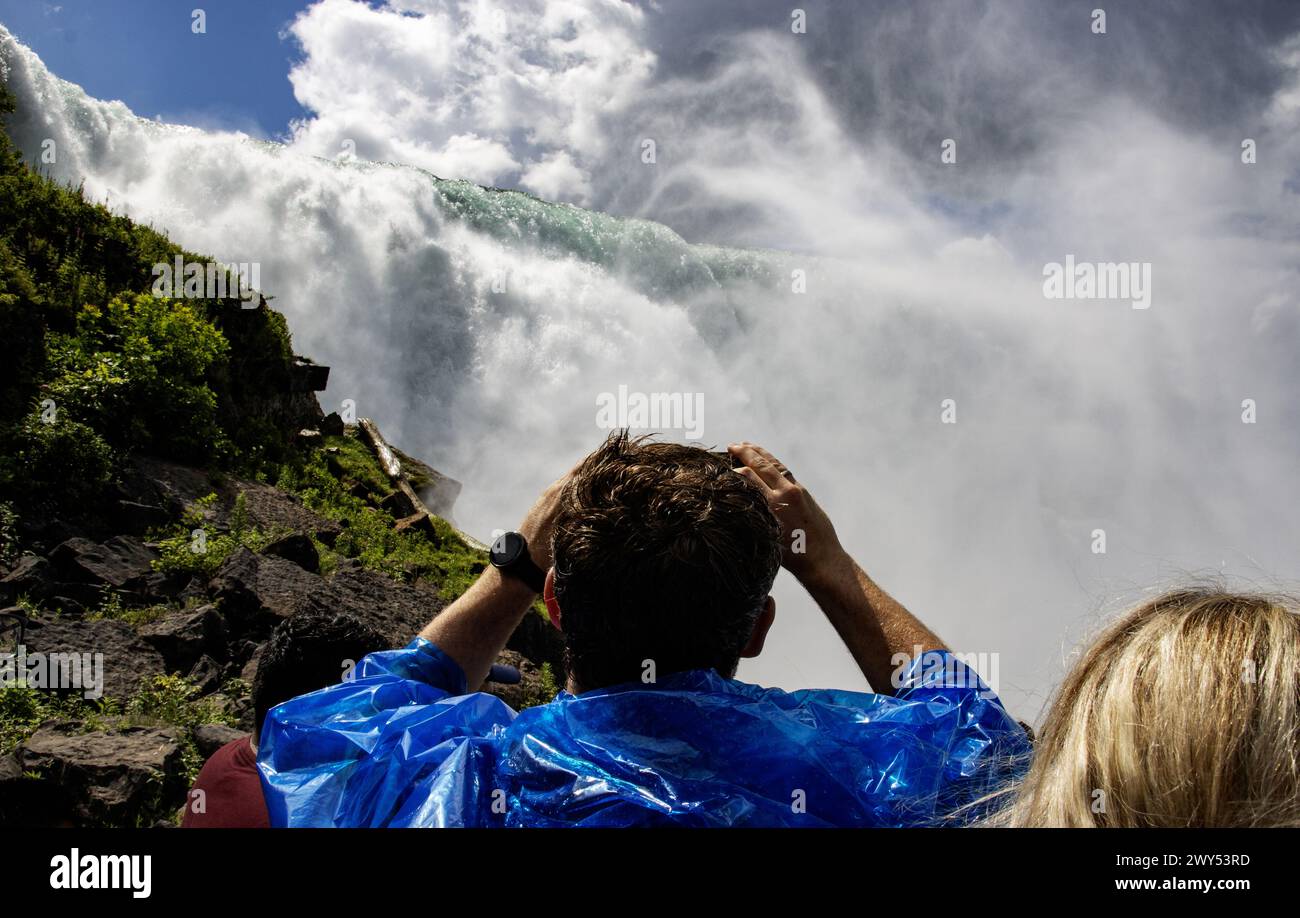 Tourists looking up and taking pictures of American Falls in Niagara Falls New York. Stock Photo