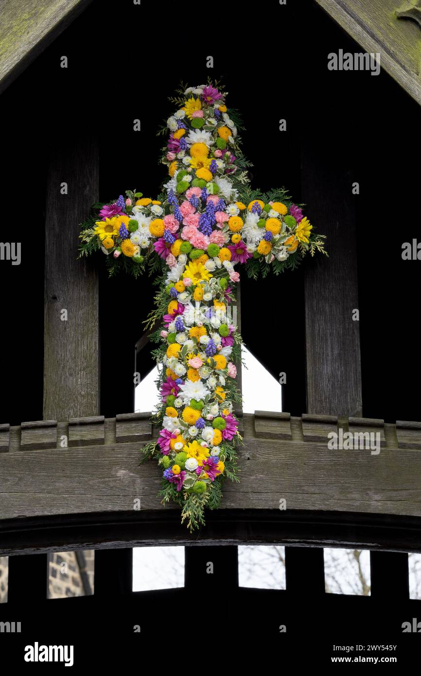 A floral Easter Cross above the lychgate at St John's Church of England in Baildon, Yorkshire, England. This is known as 'Flowering the Cross'. Stock Photo