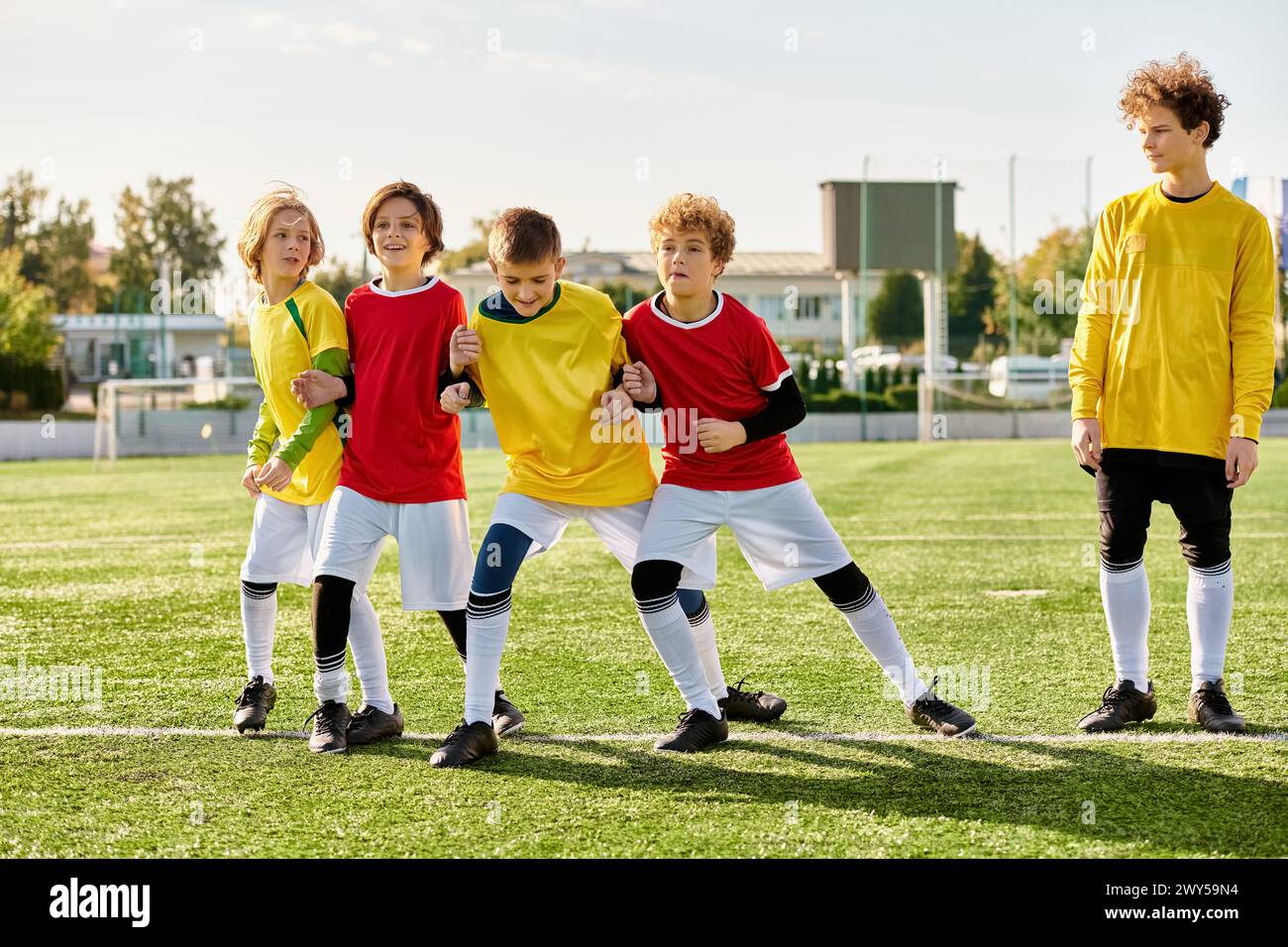 A vibrant group of youthful individuals stands proudly on the top of a soccer field, exuding energy and enthusiasm. They are united in their love for Stock Photo