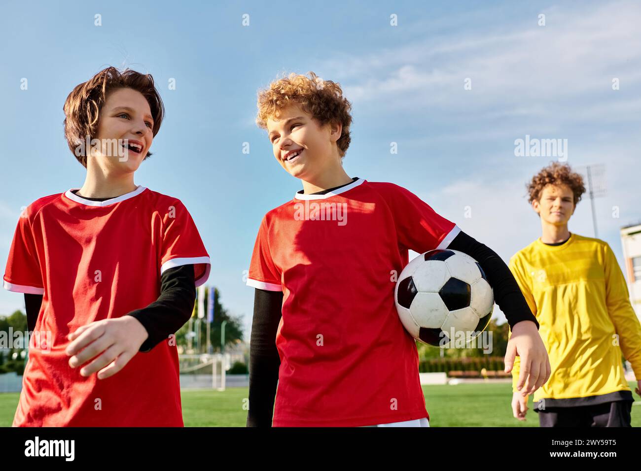 A group of young men stand next to each other on a soccer field, showcasing a sense of camaraderie and teamwork as they prepare for the game ahead. Stock Photo