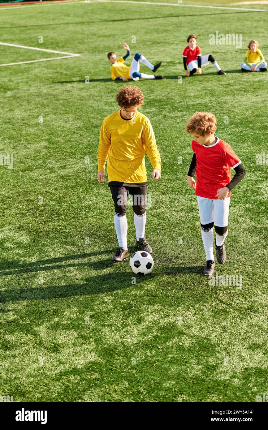 A vibrant scene of a group of children immersed in a game of soccer on a green field. They energetically kick the ball, run, and chase each other, sho Stock Photo