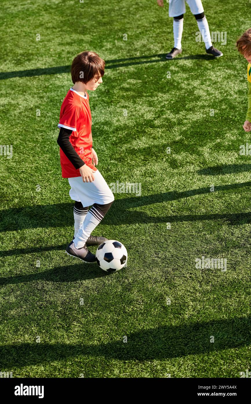 Two energetic young boys in action, kicking a soccer ball around a field with excitement and enthusiasm. Their playful and competitive spirit shines a Stock Photo