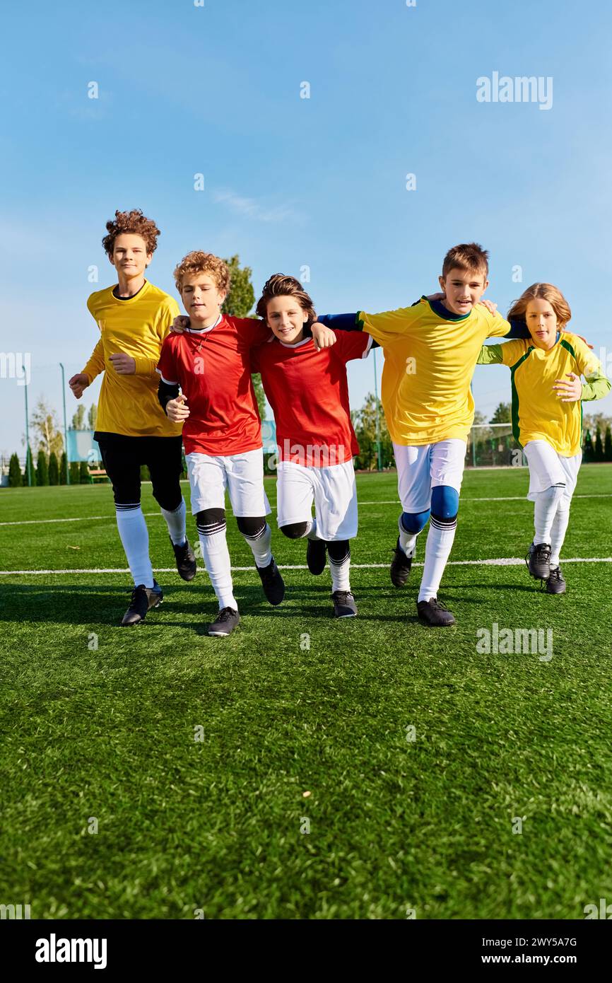 A diverse group of young people stands proudly on the top of a green soccer field, showcasing unity and camaraderie in their athletic pursuits. Stock Photo
