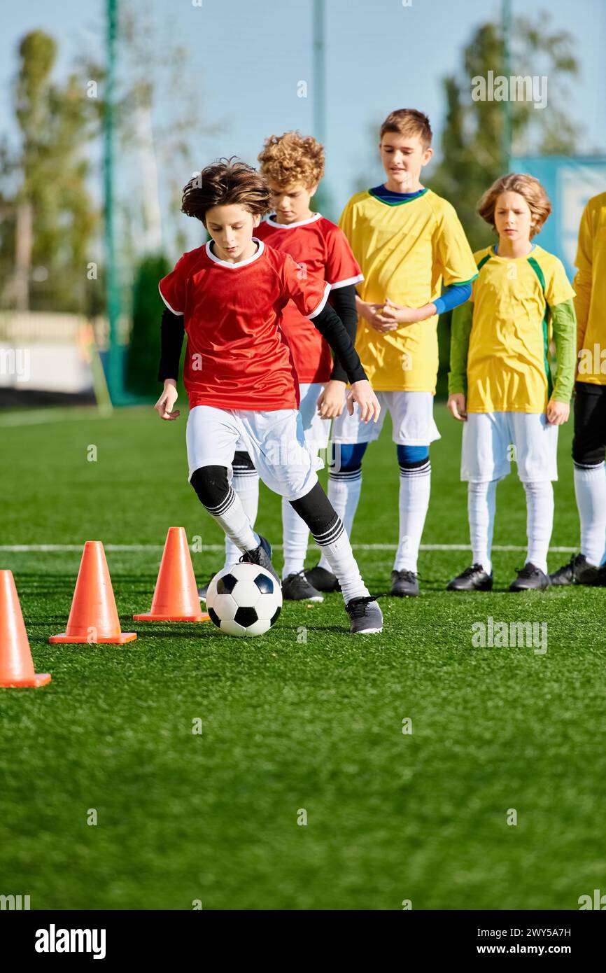 A group of vibrant young children playing an enthusiastic game of soccer on a grassy field. They are running, kicking, passing, and celebrating goals Stock Photo
